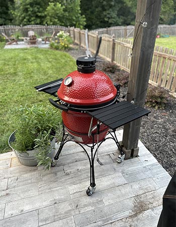 The Kamado Joe Classic Joe Grill on the corner of a deck