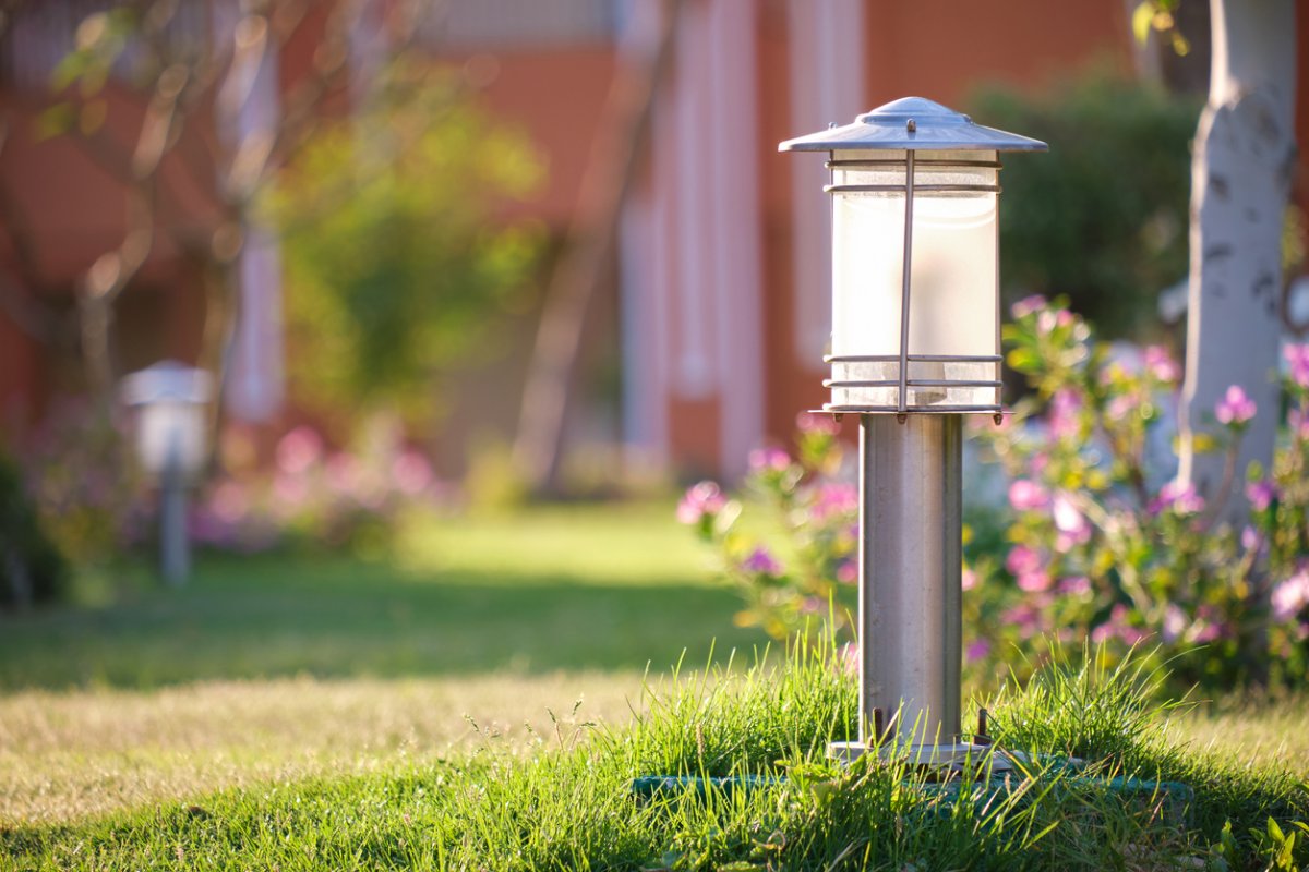 Steel garden path light in a well-maintained yard