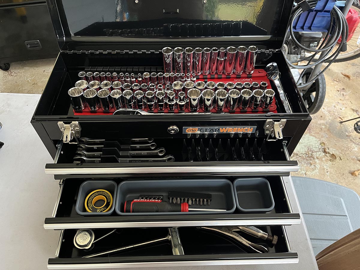 Gearwrench 3 Drawer Toolbox inside a garage with drawers open holding sockets, wrenches, and screwdrivers