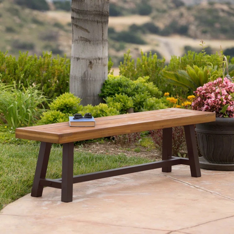 Basic wooden garden bench on patio.