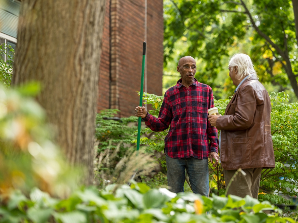 Two senior men talking in yard