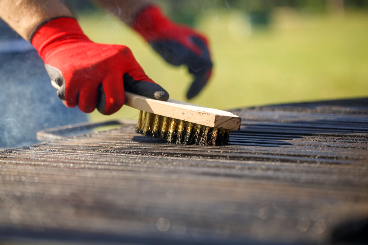 Cleaning dirty grill with brush