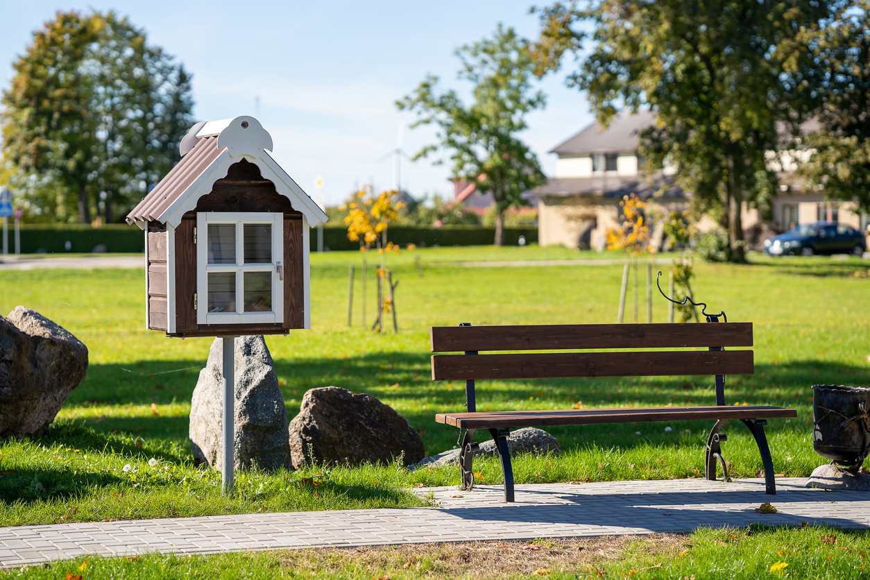 free-little-library-box-at-a-grassy-park-next-to-a-bench