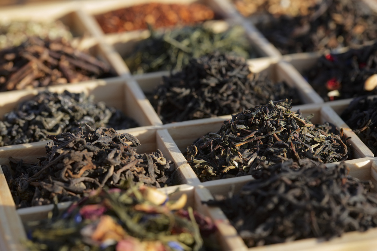 close shot of box with square dividers with different kinds of tea leaves