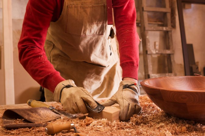 Carpenter hands at Work with Chisel and Shaver. Workshop.