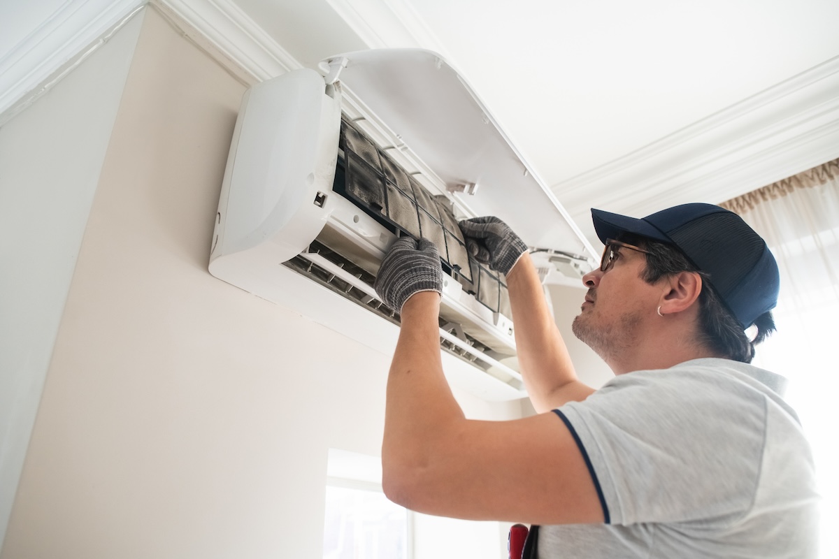 A technician replacing the moldy filter on an HVAC system.