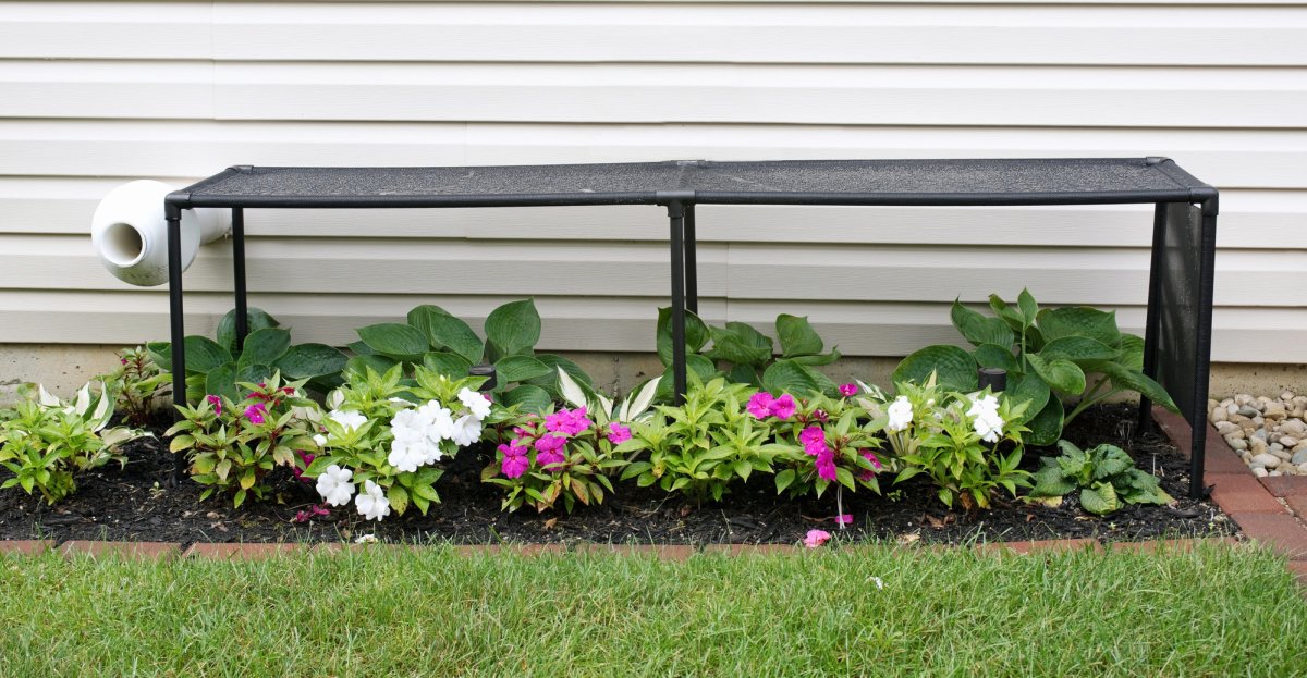 Solar shade protects a bed of flowers from the sun.