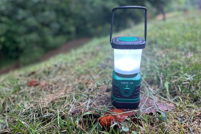 The Lepro LED lantern on a grassy spot in the woods