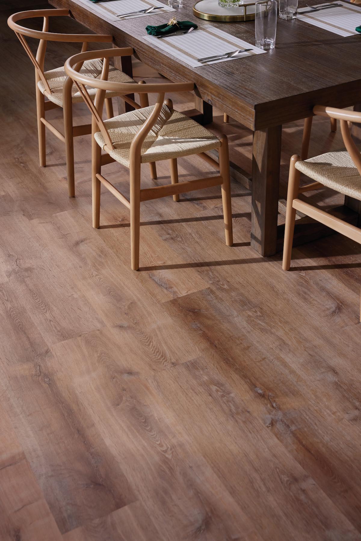 Wood dining table with rustic wood-look flooring underneath.