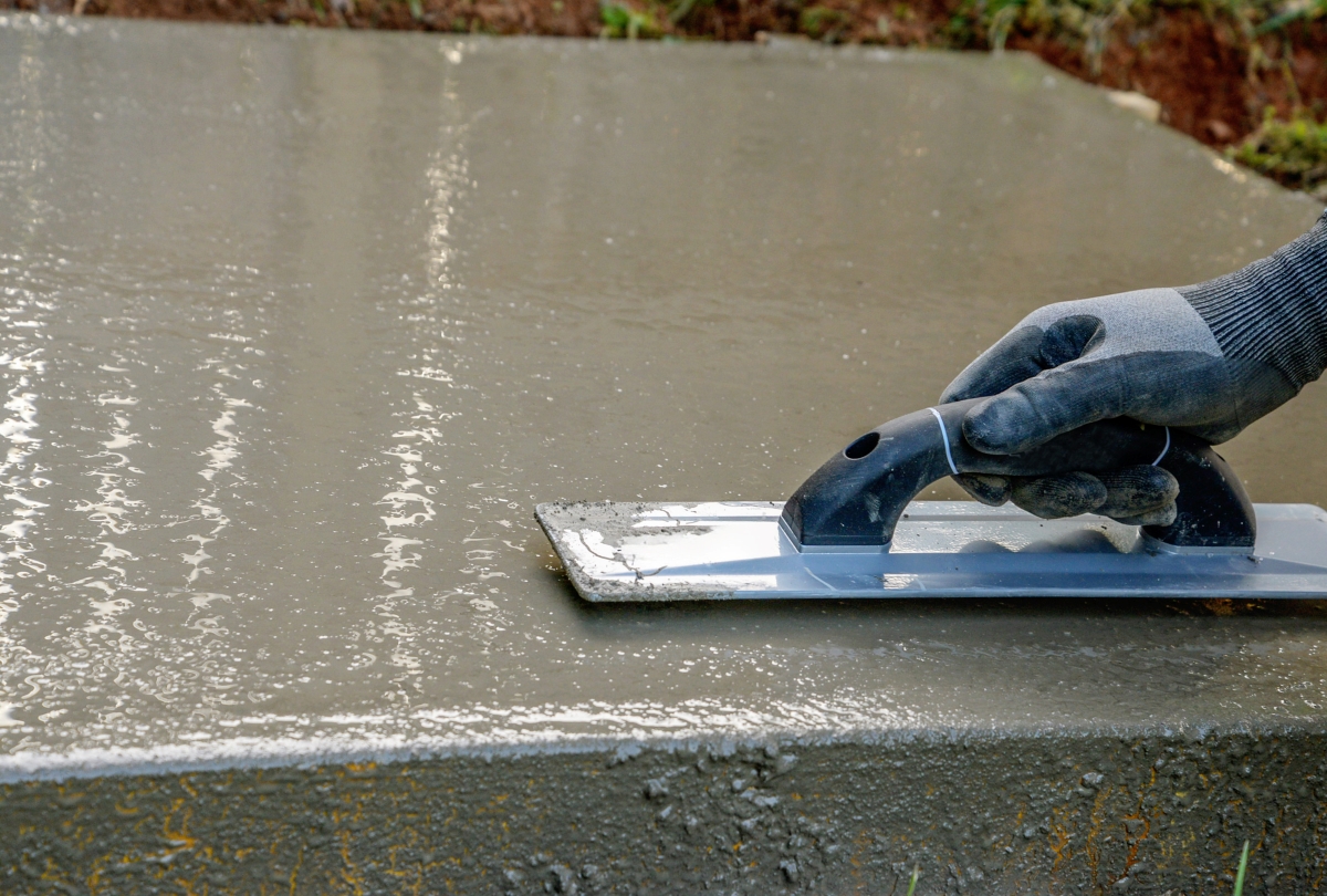 Using a trowel to smooth concrete slab.