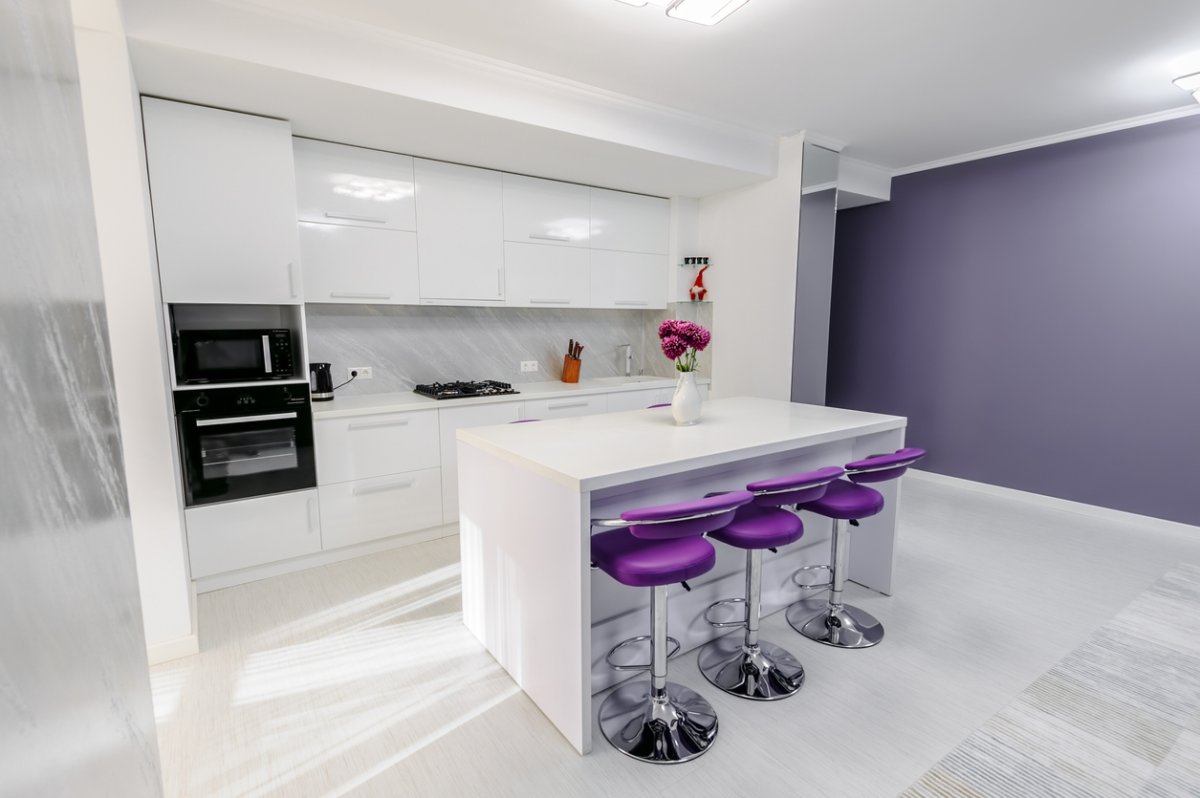 Modern white kitchen interior with purple bar chairs, minimalistic clean design