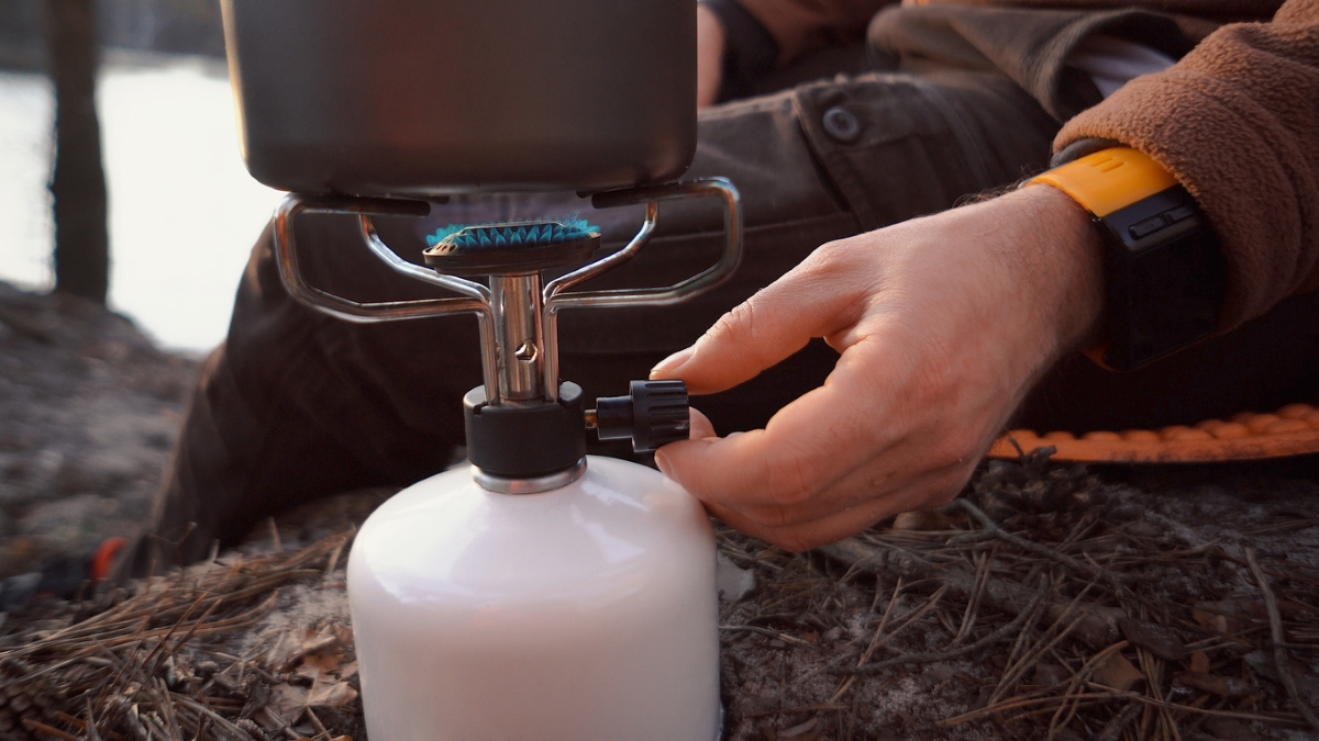 Person turning on propane cylinder