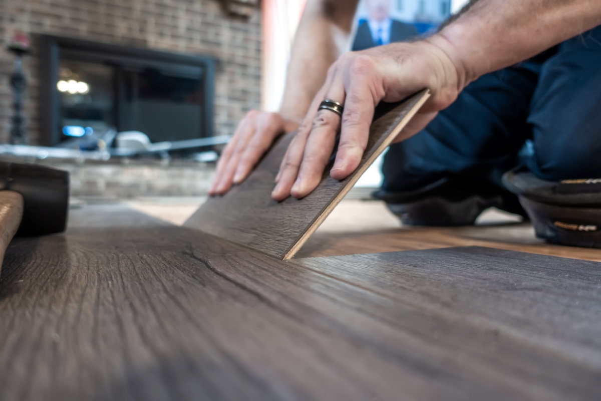 Person installing hardwood planks