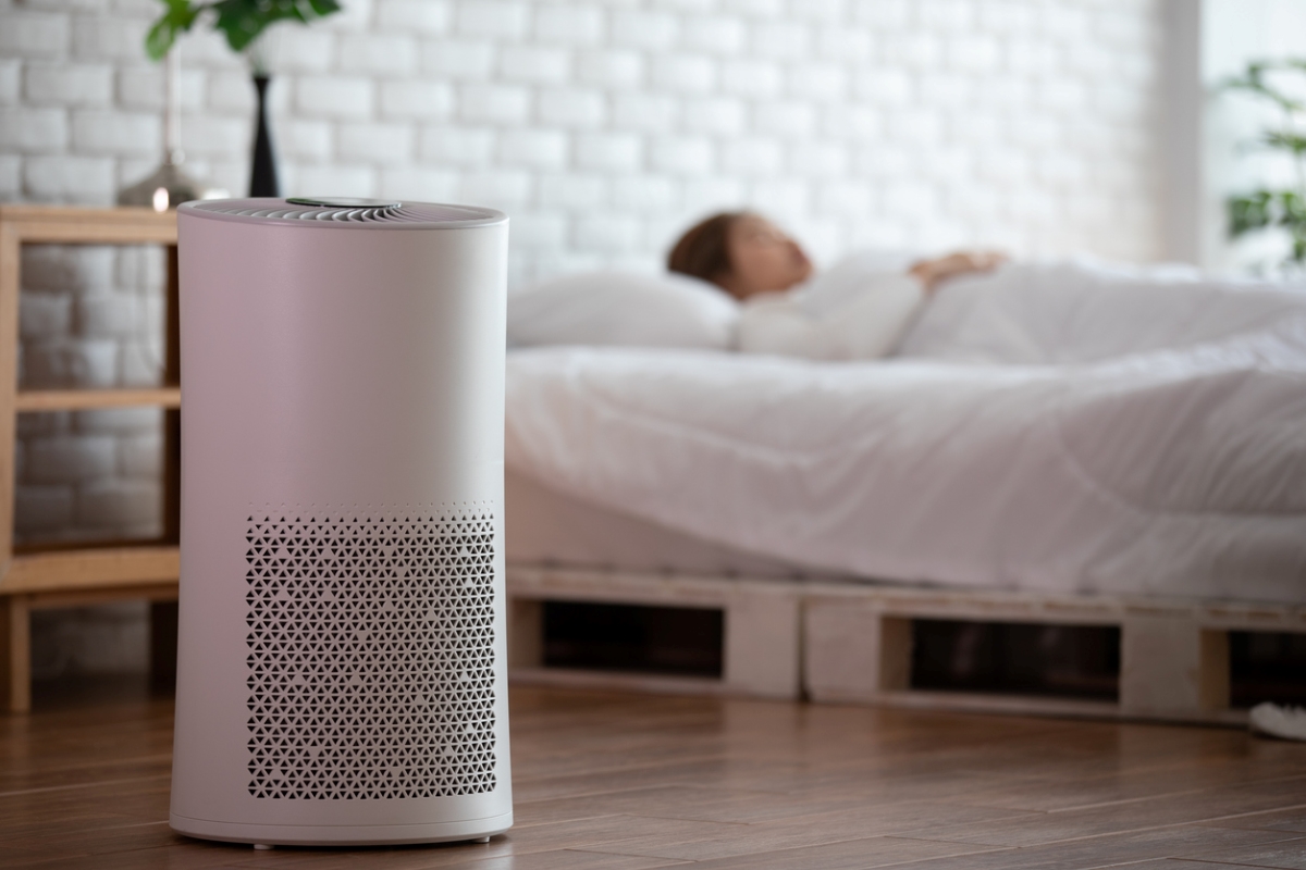 Air purifier next to sleeping woman