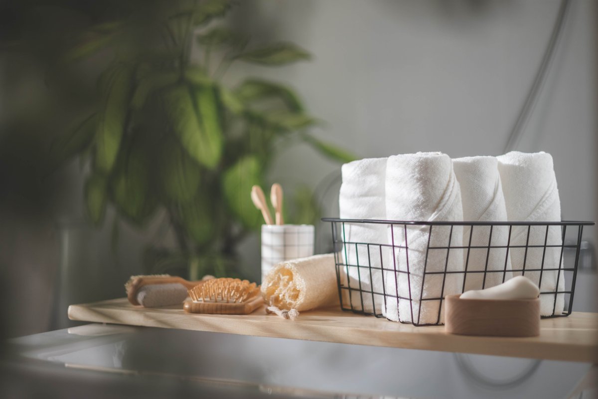 bathroom shelf with towels, loofah, brush, and tooth brushes