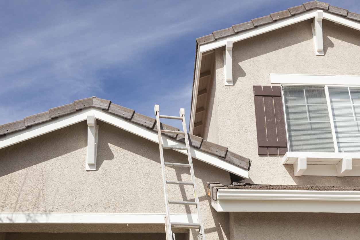 Construction Ladder Leaning Up Against A Freshly Painted House.