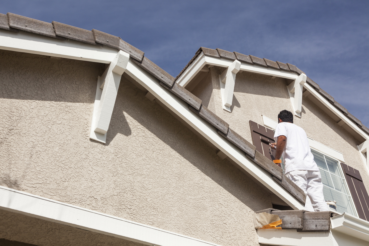 Busy House Painter Painting the Trim And Shutters of A Home.