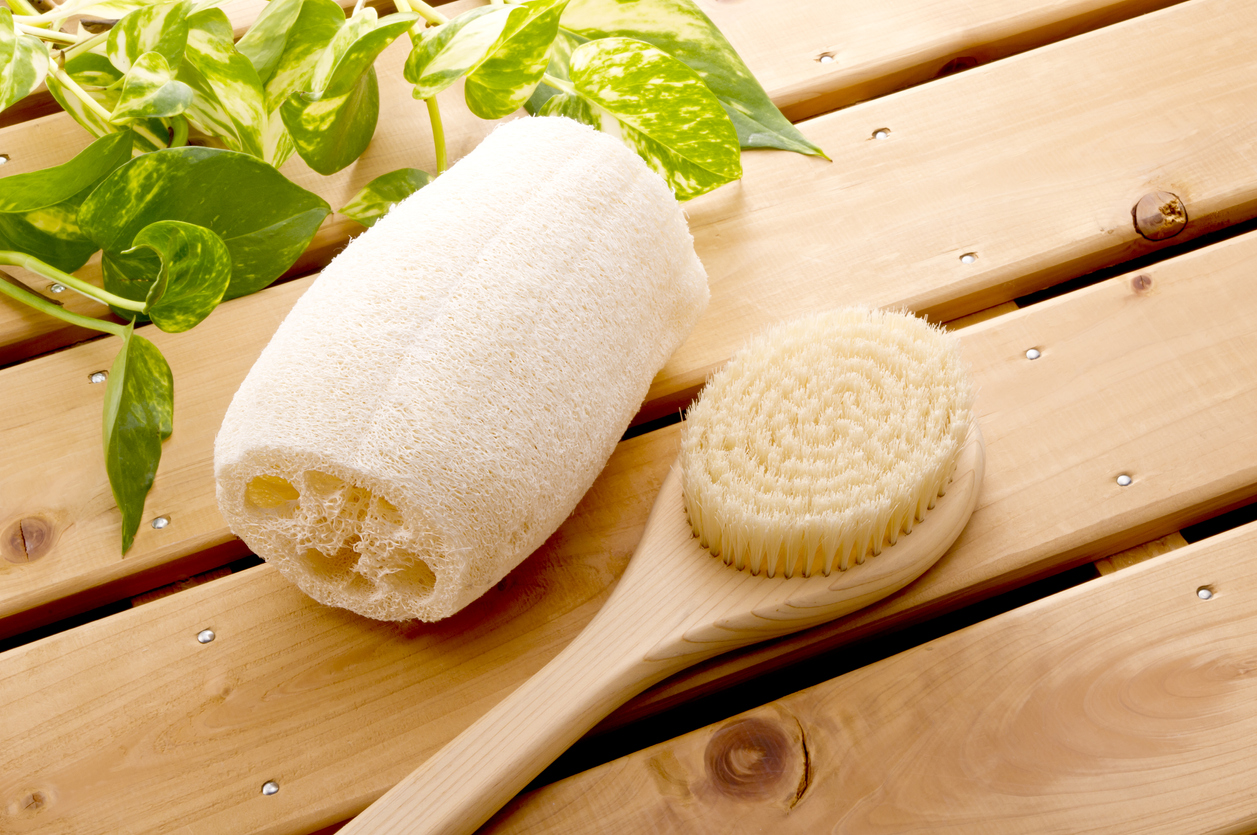 loofah on wood surface with bath brush