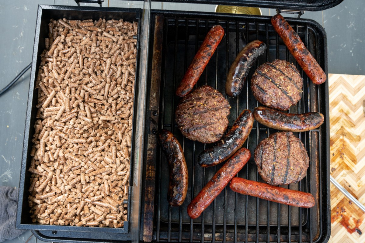 A full hopper next to meat grilling on the best pellet grill under $500