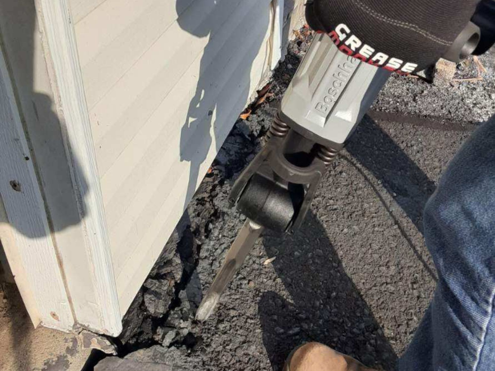 A person using the best jackhammers option to break up a cement wall