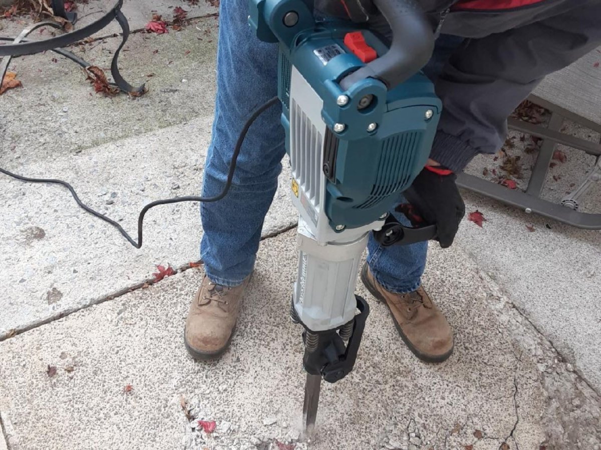 A person using the best jackhammers option to break up a cement floor