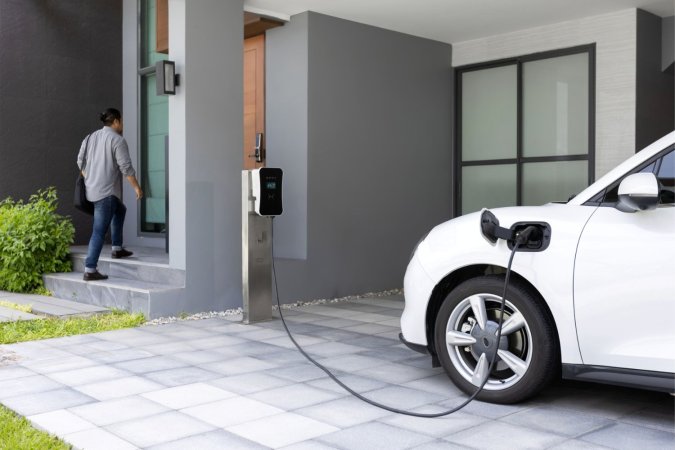 A view of en EV charging outside a home.