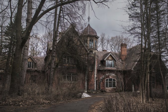 Old abandoned gothic house. The ruined mansion stands in the park. Gothic background. Halloween party place