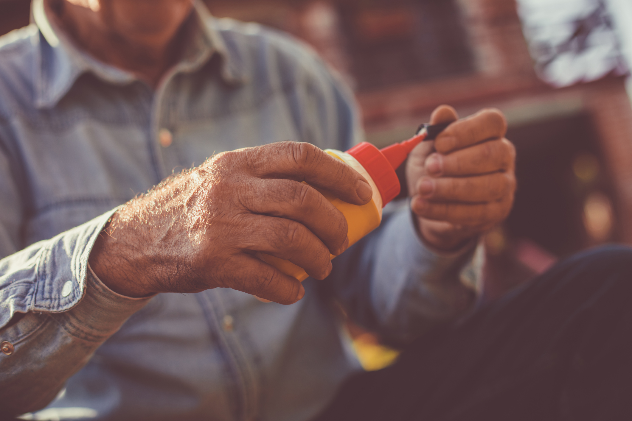 Senior man holding glue