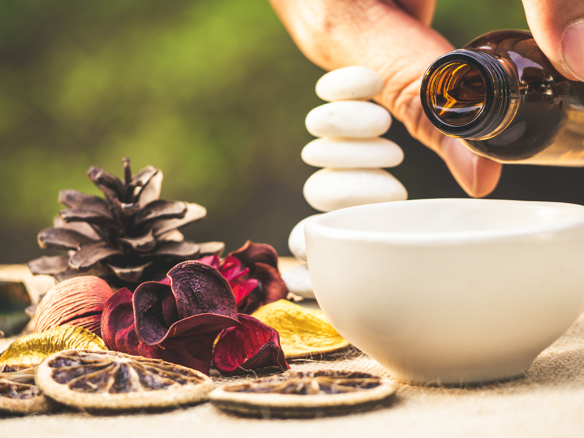 The essential oil falling from glass dropper into organic bio alternative medicine, brown bottle.