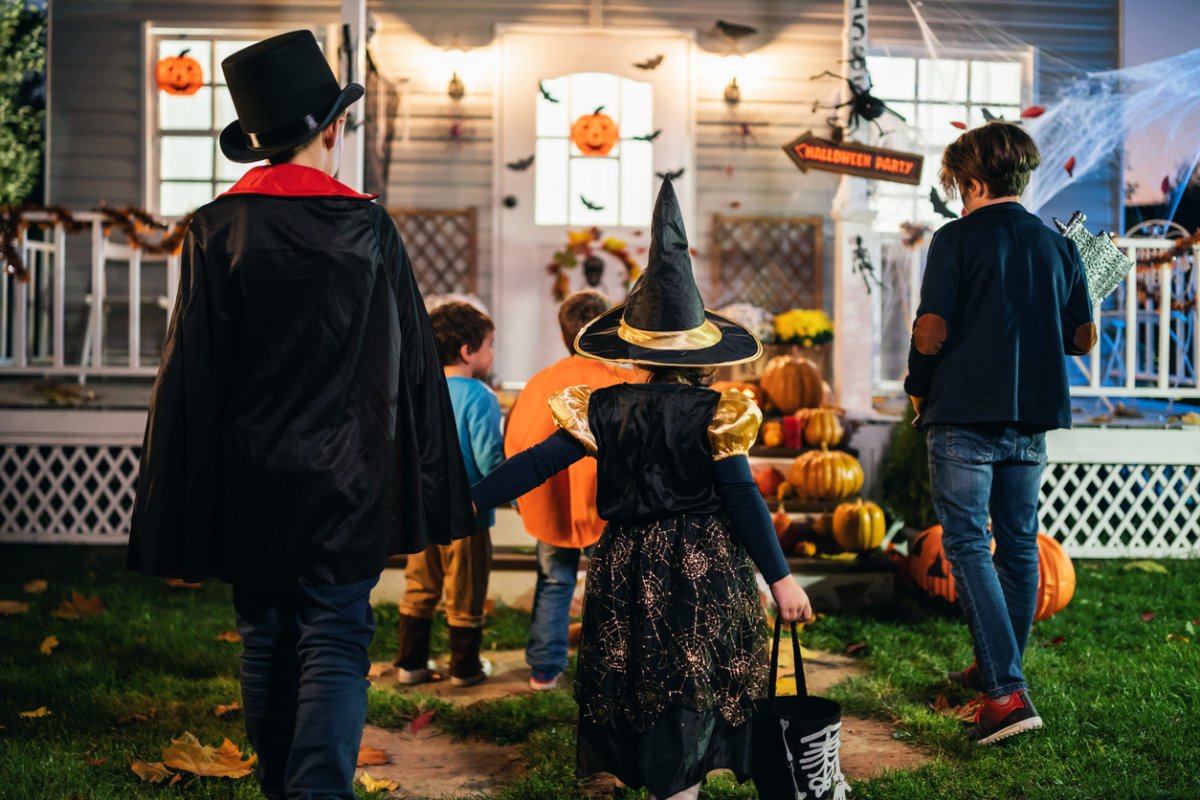 Young kids trick or treating at night during Halloween