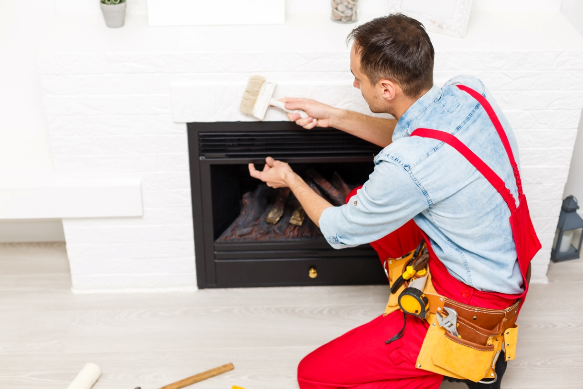 Person using brush to clean fireplace