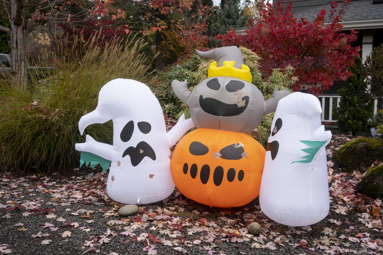 Lake Oswego, OR, USA - Oct 28, 2021: Funny Halloween inflatables are seen in a front yard with colorful fall foliage and fallen leaves in Lake Oswego, Oregon, during the holiday season.