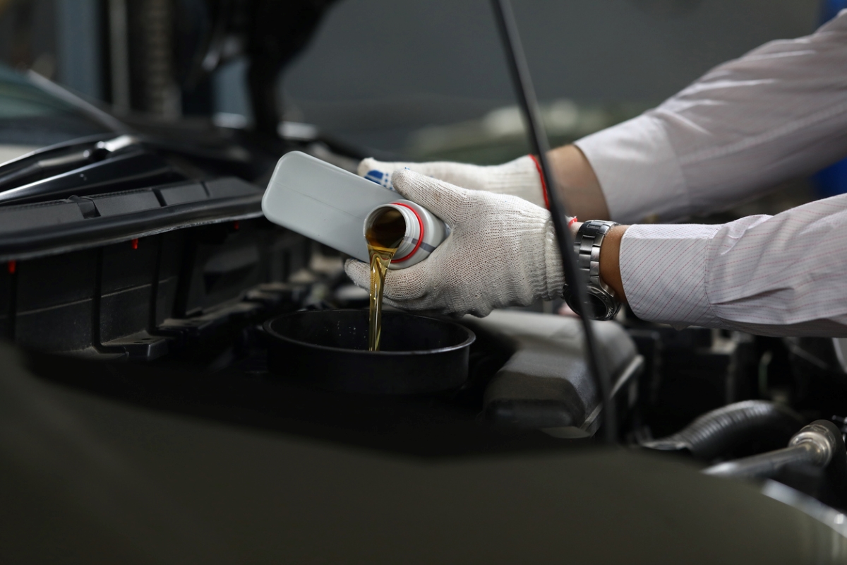 Person pouring oil in car