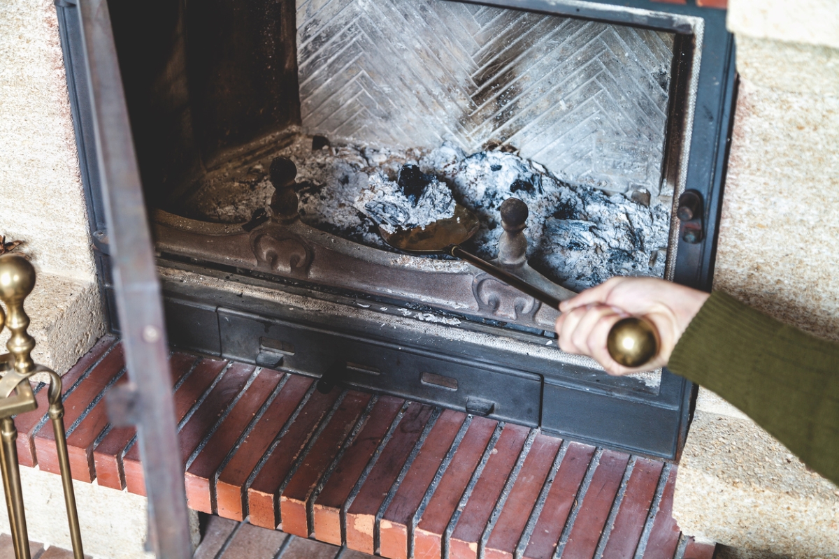 Person removing fireplace ashes