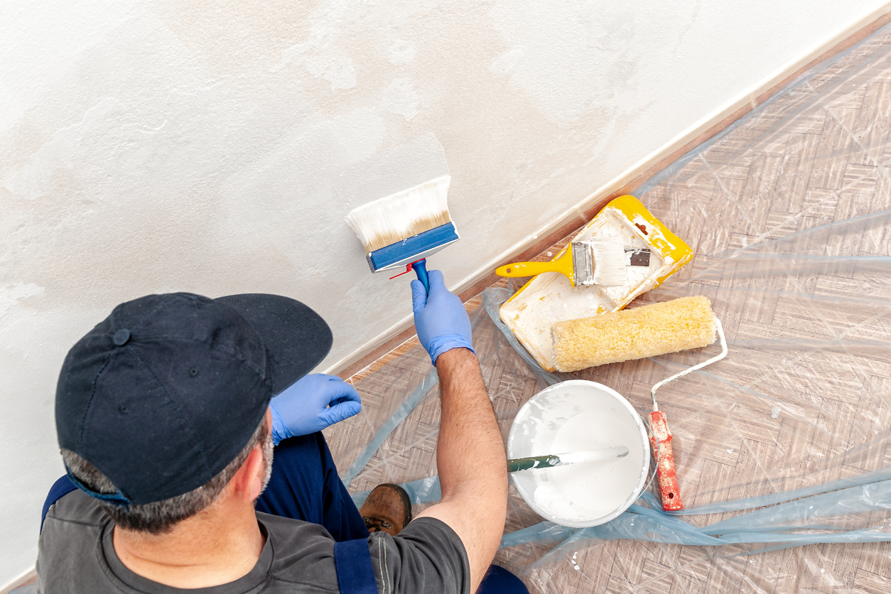 overhead view of man painting bottom of wall