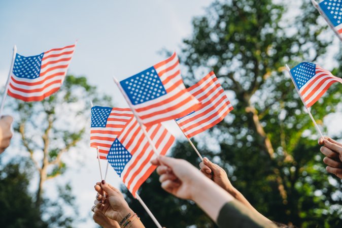 Group of people waving small American flags