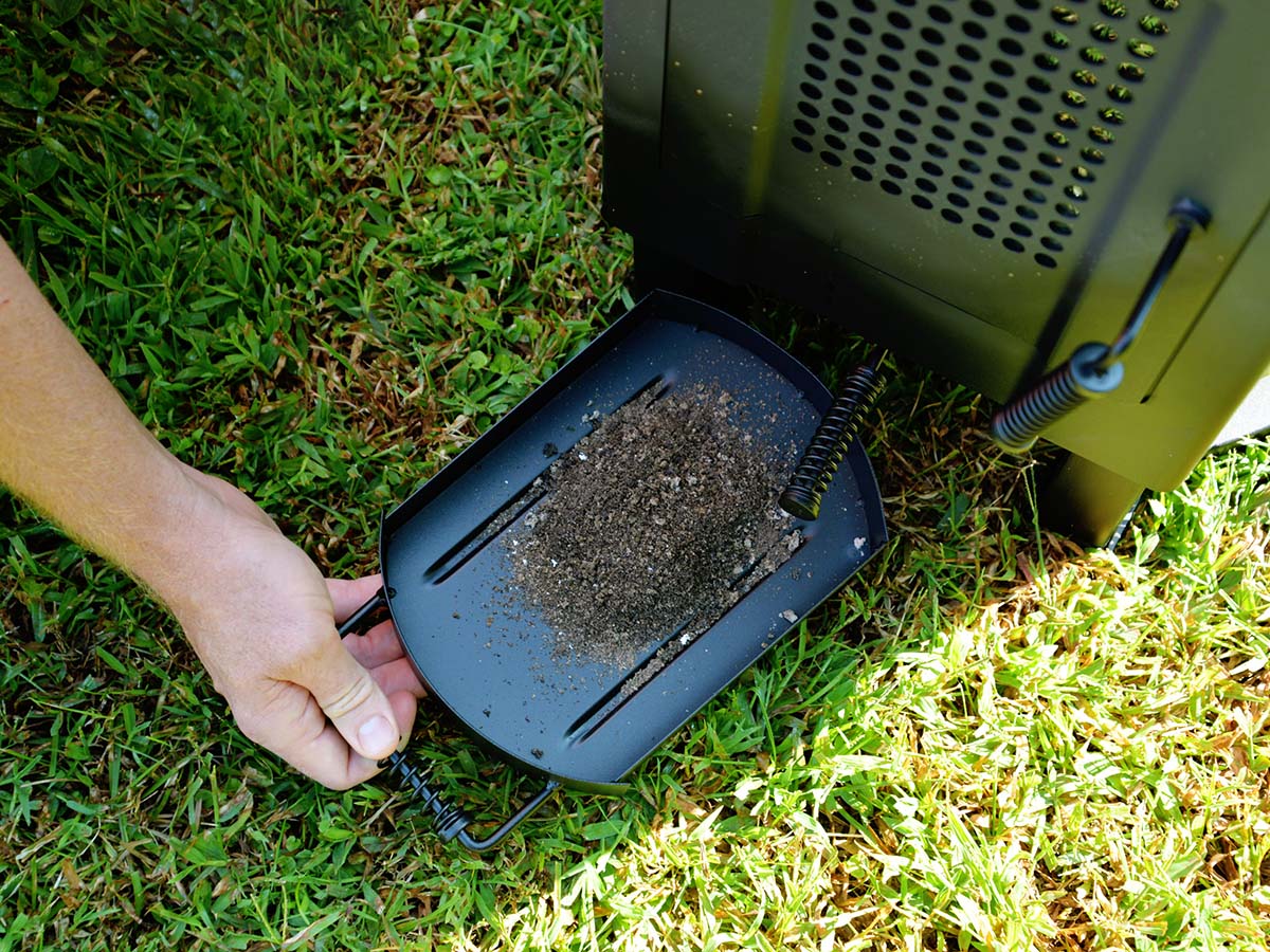 Person pulling out ash tray on a Solo Stove Tower Patio Heater.