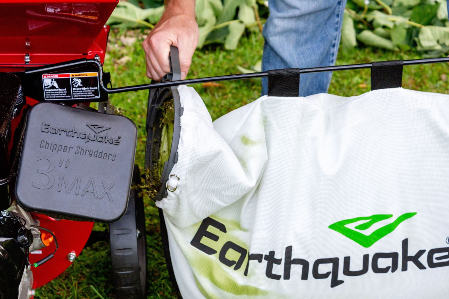 Person removing full bag of wood chips from Earthquake K33 wood chipper