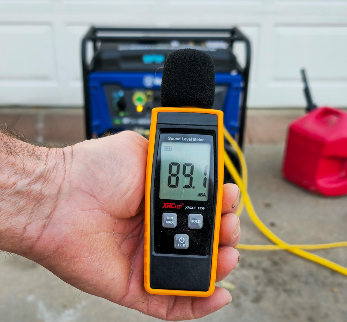 Person using a digital decibel meter to measure the noise from the Westinghouse WGen9500DF Generator.