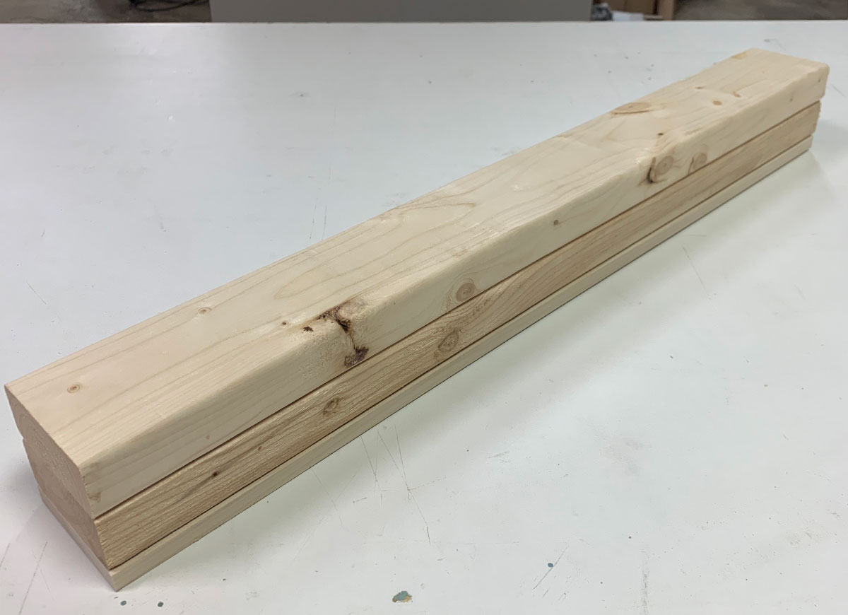 Stacked wood boards on a workbench.