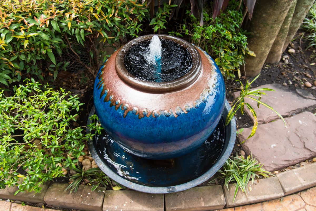 overhead view of round ceramic fountain near landscaped garden