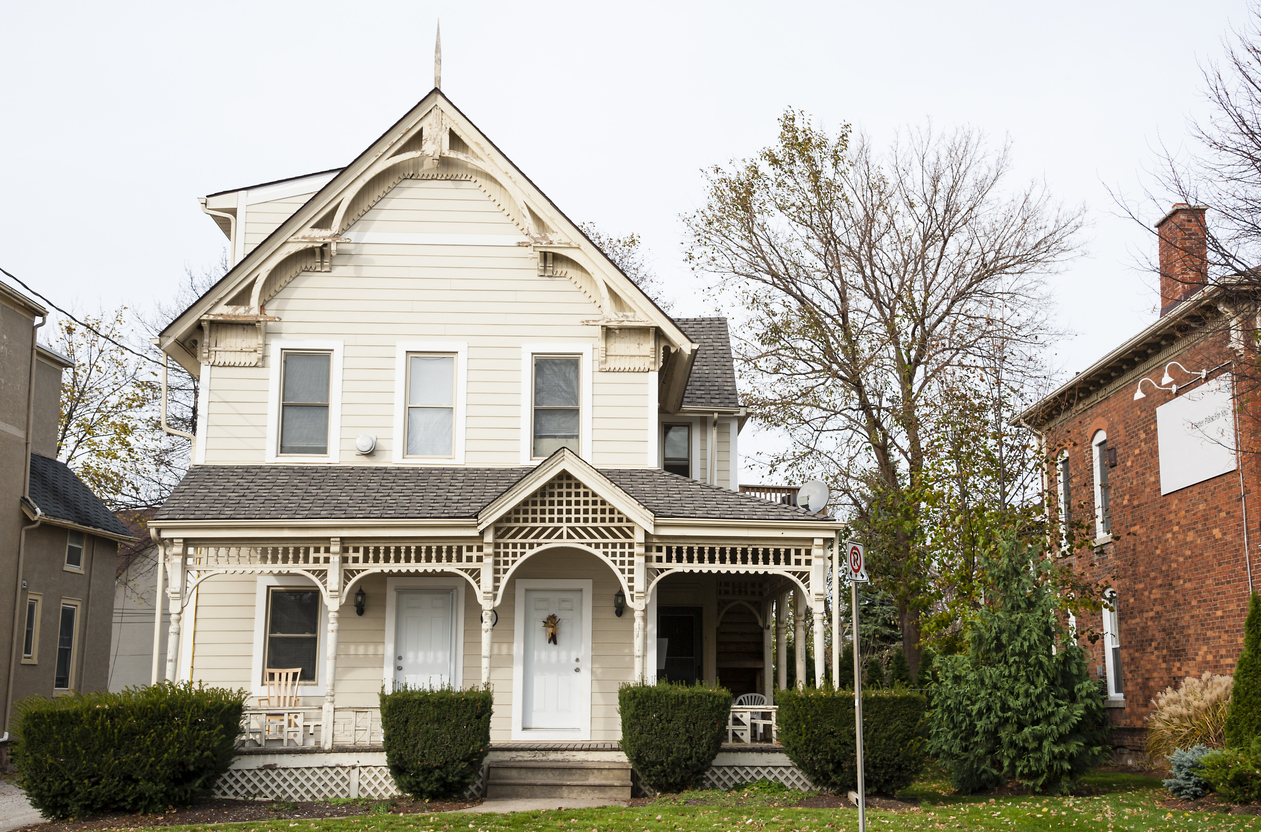 An older style white wooden house in the autumn season.