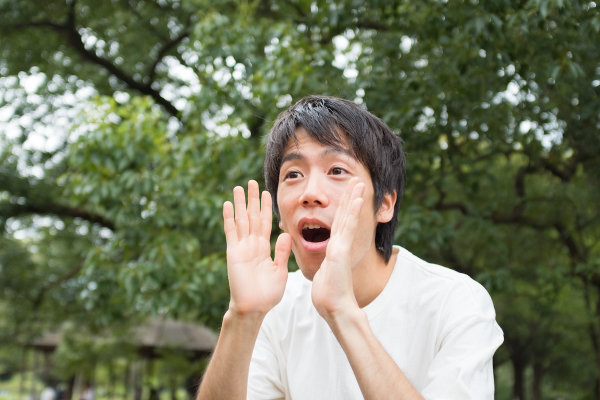 A person making crow sounds in a backyard.