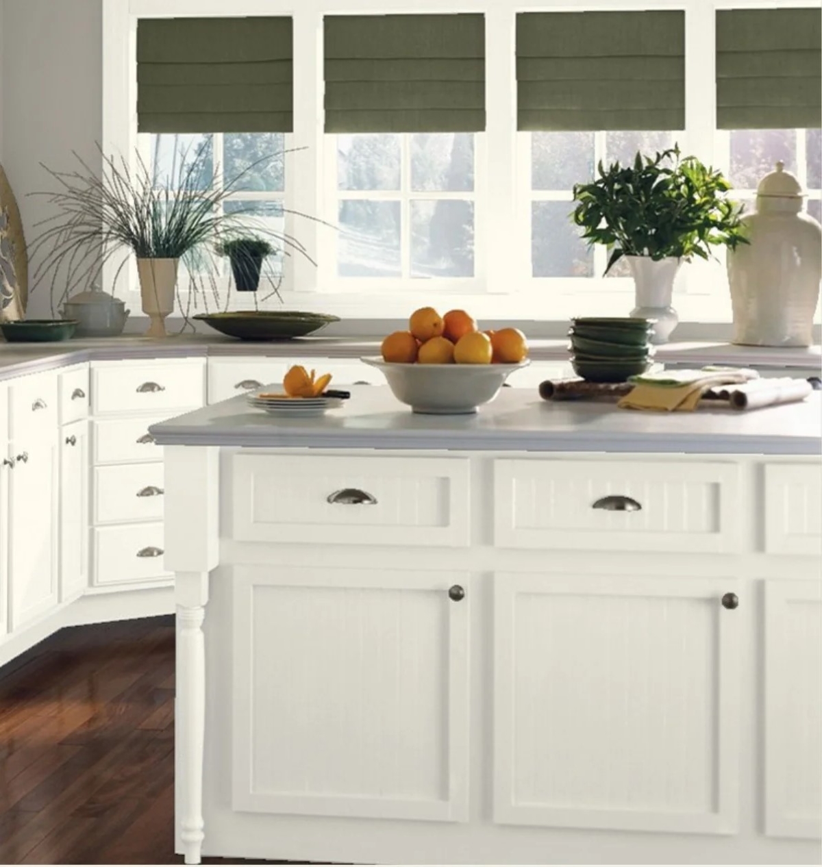 White kitchen with green curtains.