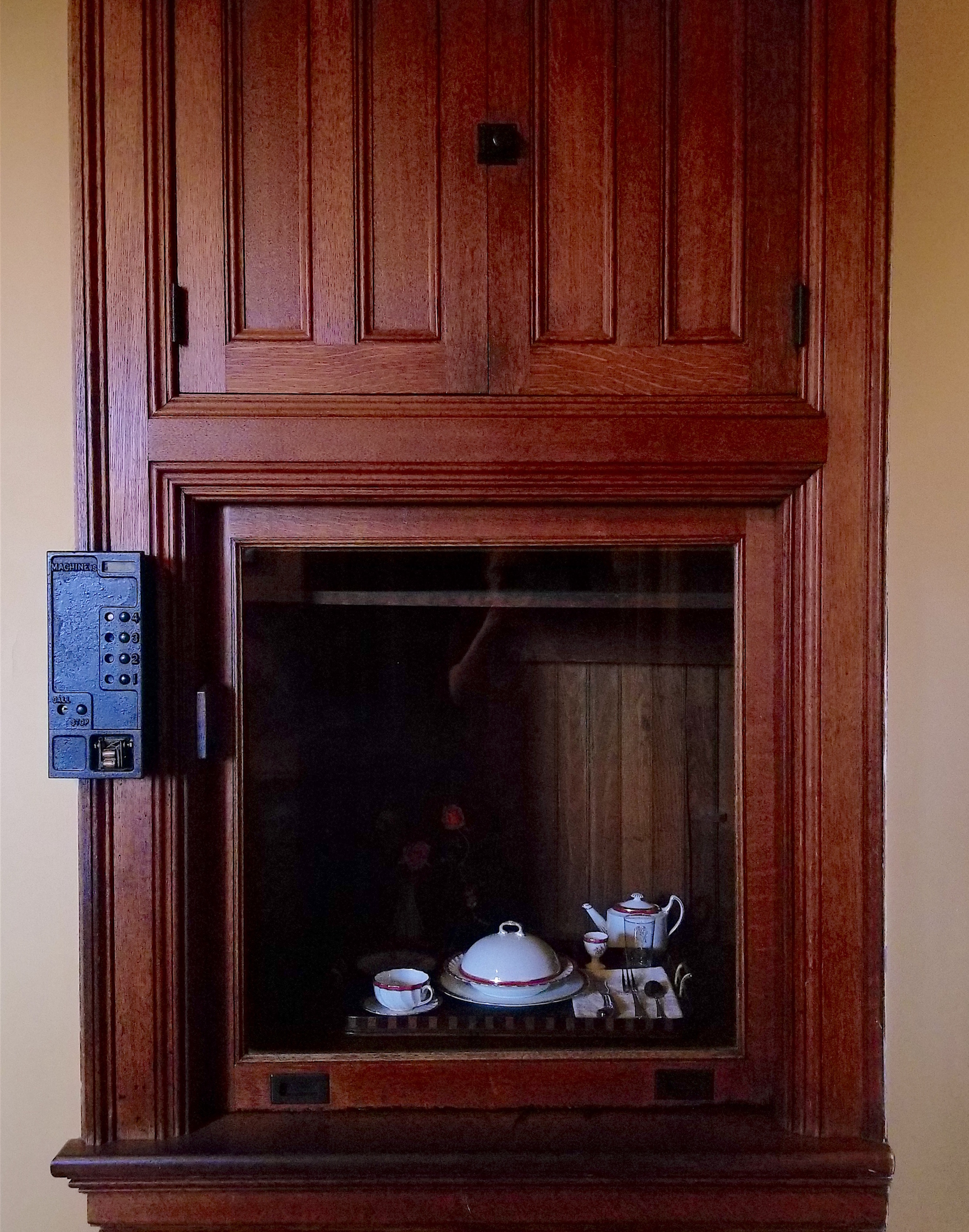 old wooden dumbwaiter with tea set