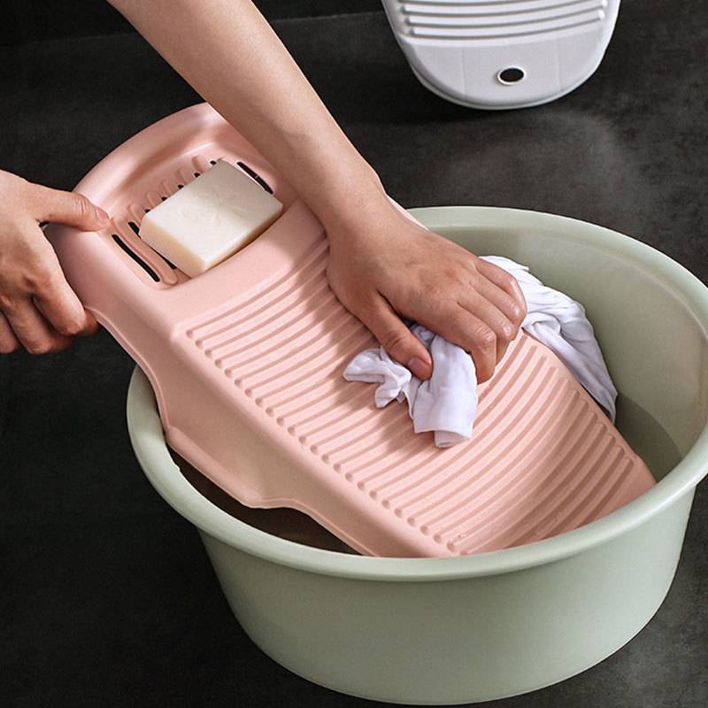 Woman using washboard to wash clothes