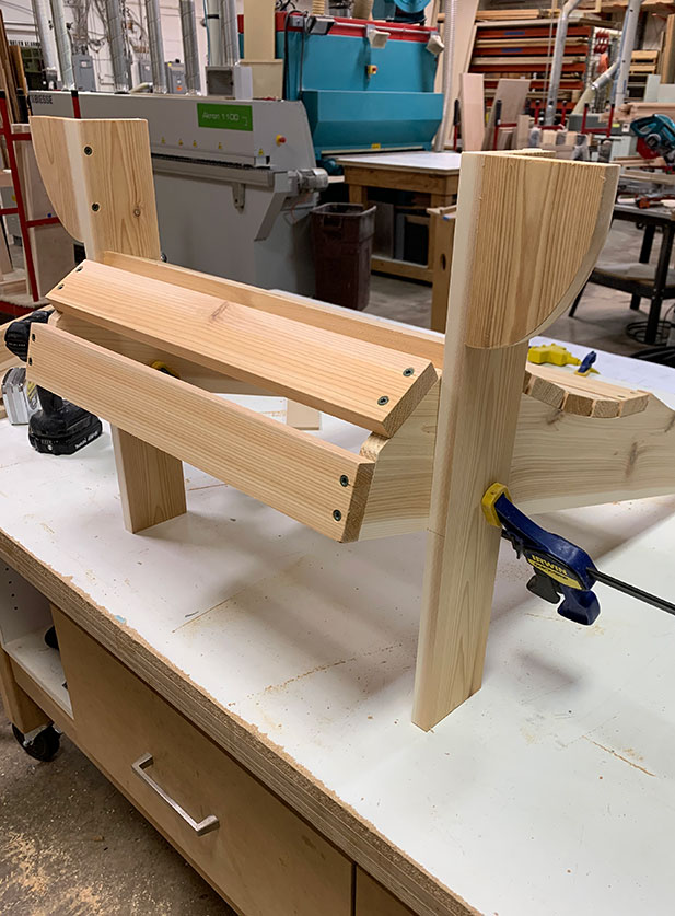 A partially built DIY Adirondack chair in a home workshop.