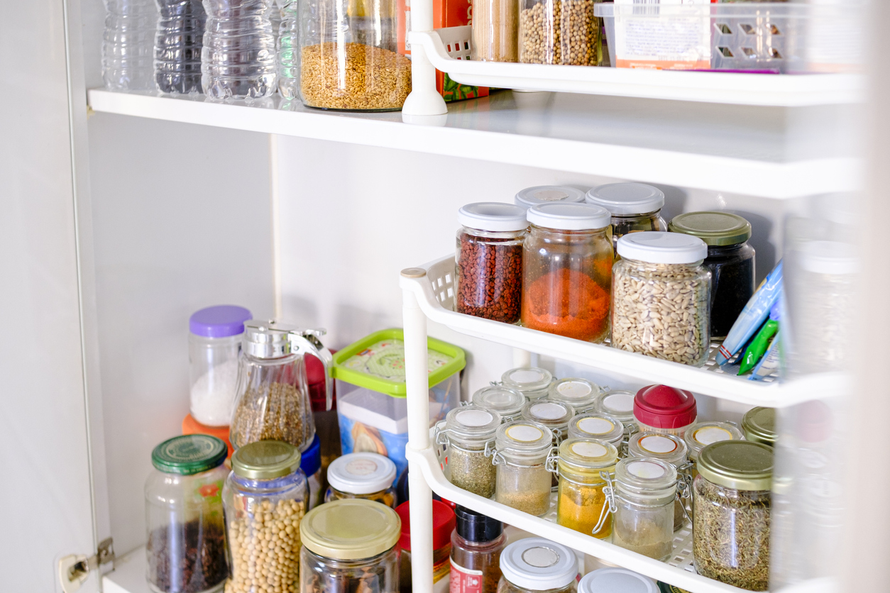 Well stocked pantry with a variety of pots and cans.