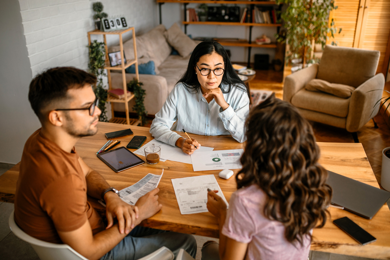 Young female financial advisor helping couple with their money investment and home budget