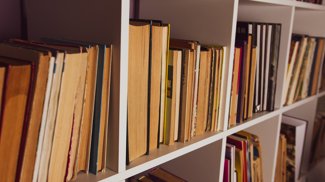 Old books on a home bookshelf.